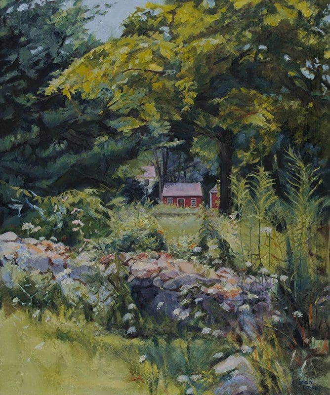 Red cottage surrounded by trees and greenery.