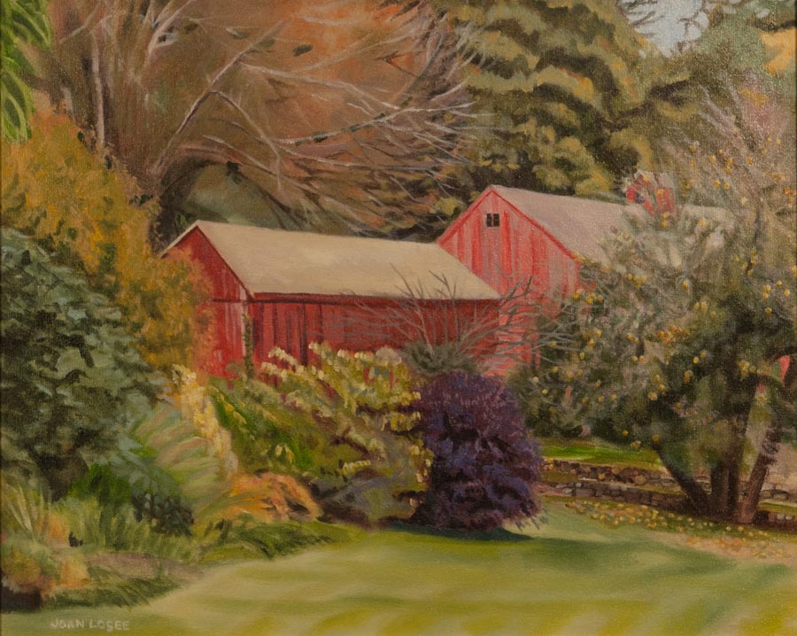 Red barn surrounded by autumn foliage.