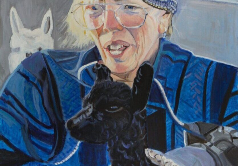 Person holding a black alpaca, colorful background.